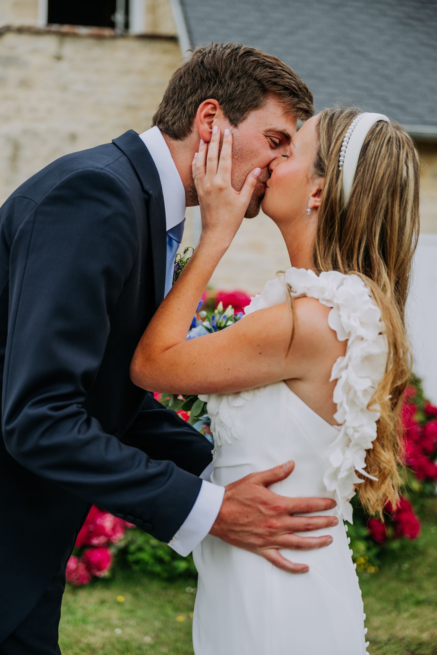 Anastasia et Harrison s'embrassent devant un massif de fleurs
