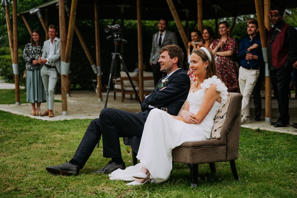 Anastasia et Harrison installés dans des fauteuils sur la pelouse, pendant la réception