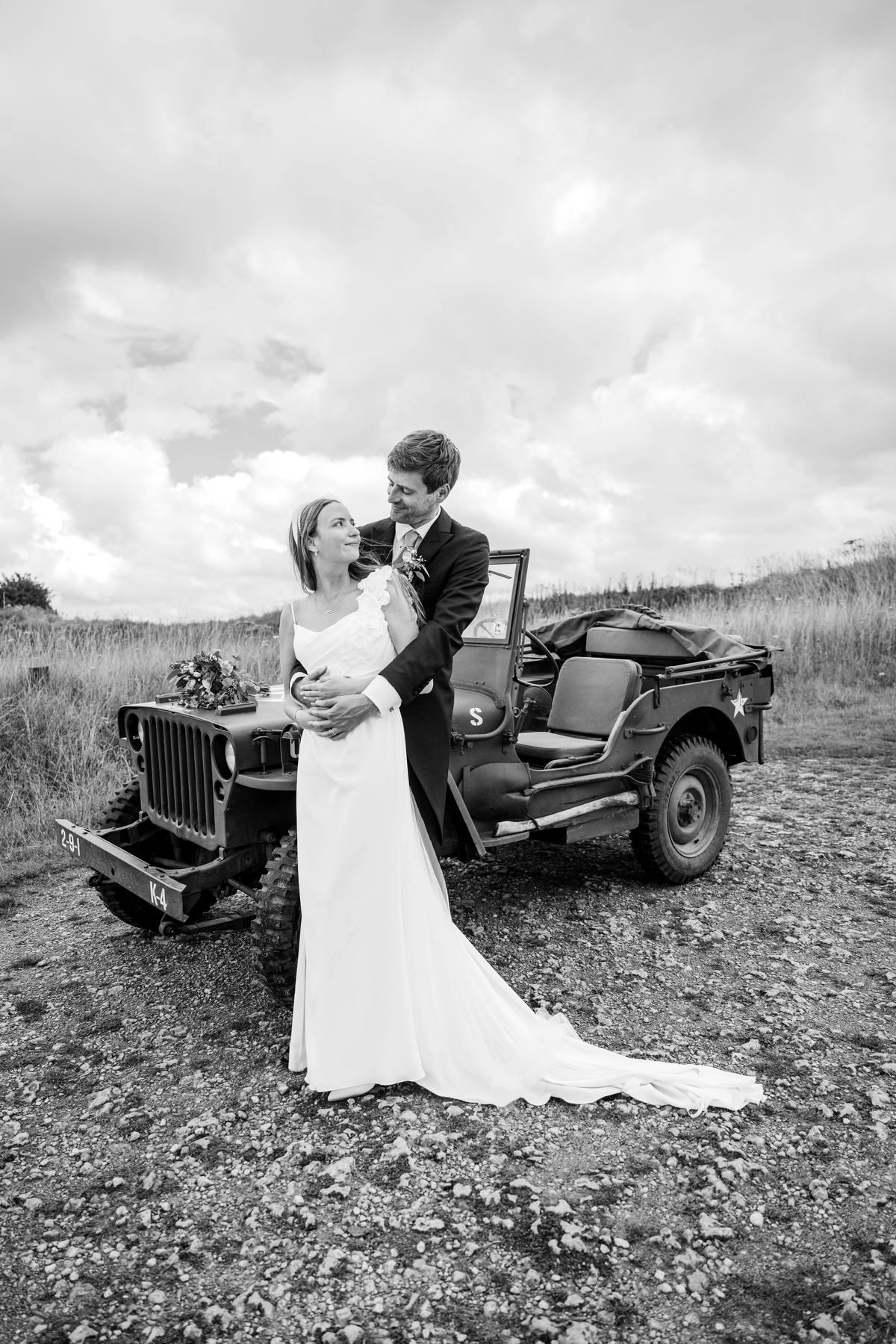 Anastasia et Harrison devant une jeep ancienne en haut d'une falaise