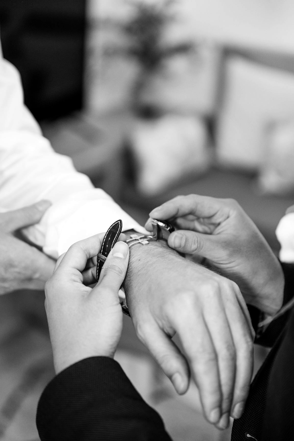Gros plan sur des mains qui attachent une montre au poignet pendant les préparatifs