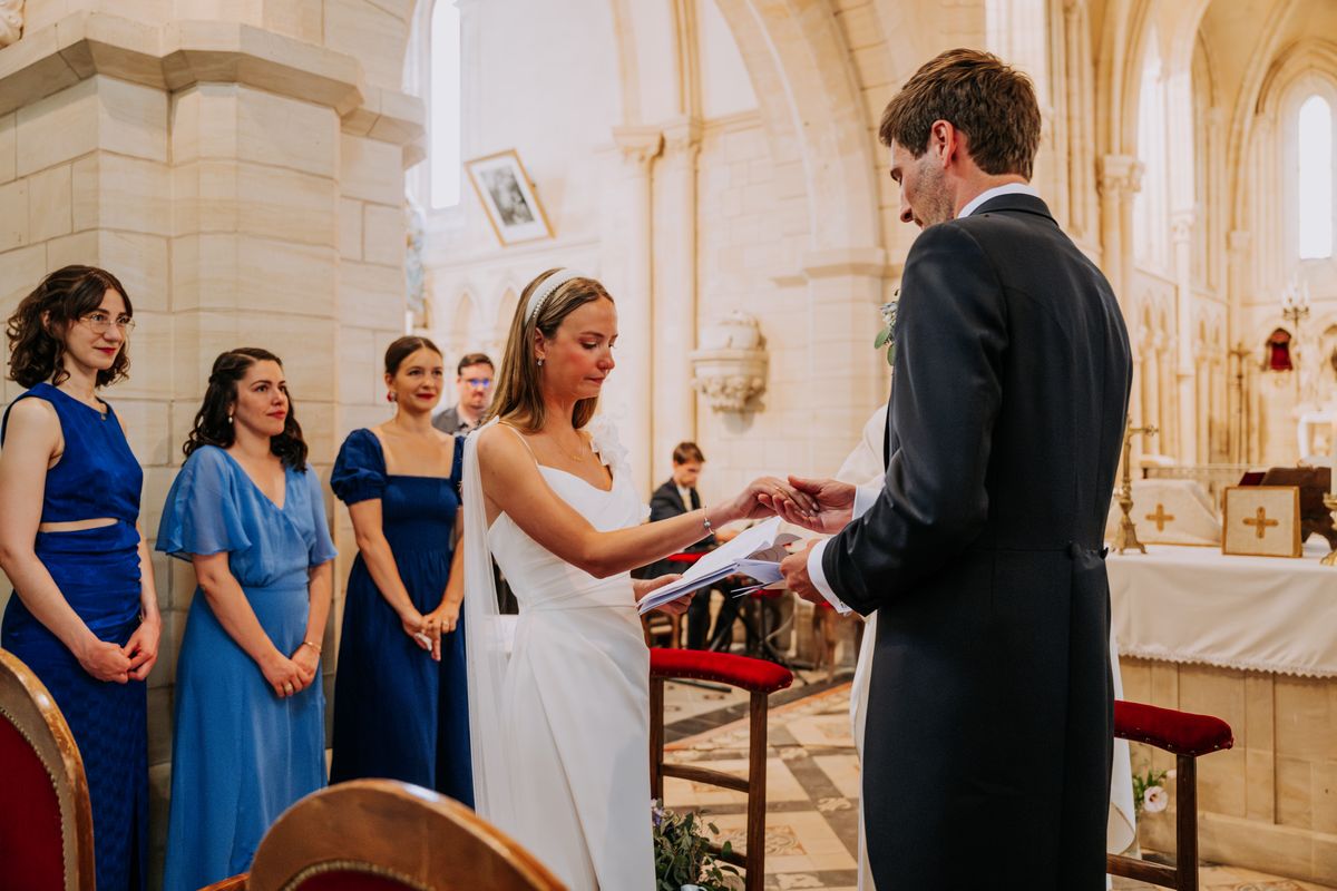 Anastasia et Harrison échangent leurs voeux dans l'église, les demoiselles d'honneur en bleu à leurs côtés